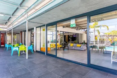 a lobby with tables and chairs and windows at The Sandown 178 by CTHA in Cape Town