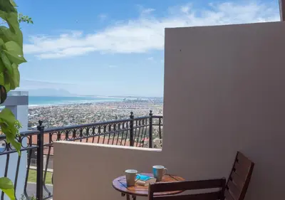 a balcony with a table and a view of the ocean at Blue Horizon Guest House in Gordonʼs Bay