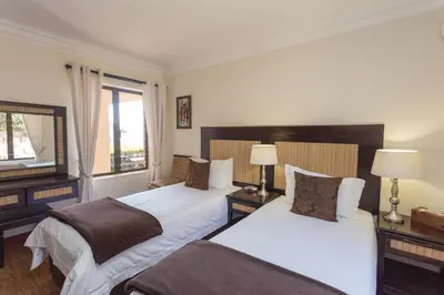 a bedroom with two beds and two lamps and a mirror at Blue Horizon Guest House in Gordonʼs Bay
