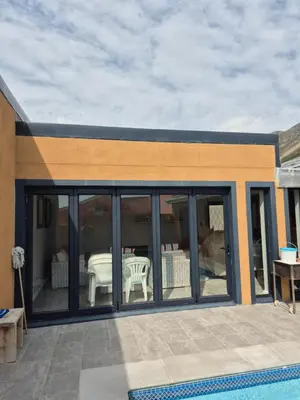 a house with sliding glass doors and a patio at Remmy Place in Hawston