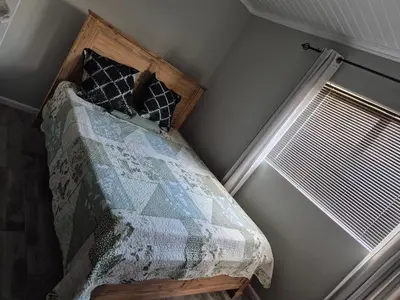 a bedroom with a bed with a quilt and a window at Remmy Place in Hawston