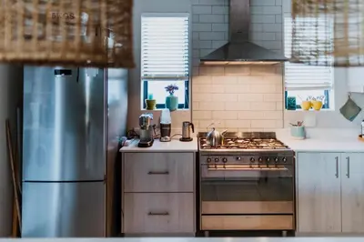 a kitchen with a stove and a refrigerator at Between the Ocean and Winelands in Croydon