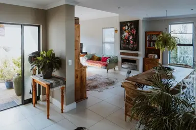 a living room with a couch and a fireplace at Between the Ocean and Winelands in Croydon