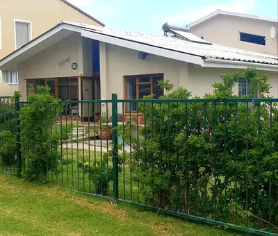 a green fence in front of a house at Happidaze in Hermanus