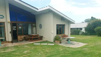 a white house with a picnic table in a yard at Happidaze in Hermanus