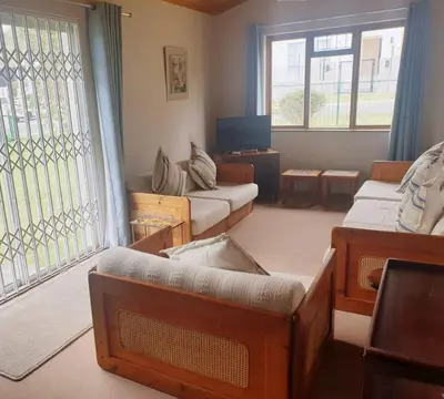 a living room with a couch and a tv at Happidaze in Hermanus
