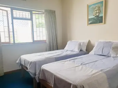 two beds in a room with two windows at Happidaze in Hermanus