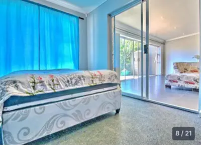 a bedroom with a bed and a large window at S&R Guesthouse in Cape Town