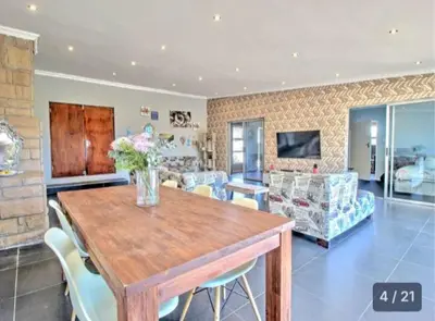 a living room with a wooden table and chairs at S&R Guesthouse in Cape Town