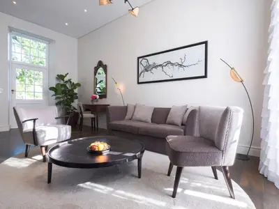 a living room with a couch and a table and chairs at Adara Palmiet Valley Luxurious Boutique Farm Hotel in Paarl