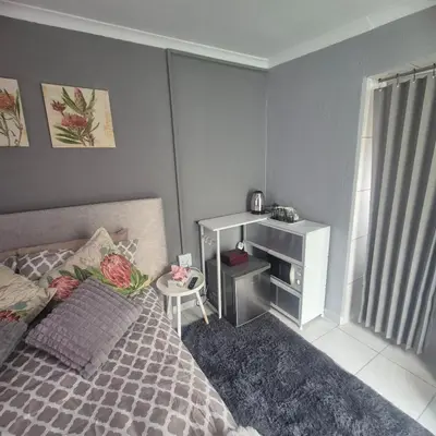 a small bedroom with a bed and a desk at White Lilly