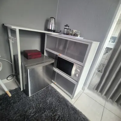 a small kitchen with an open oven in a room at White Lilly