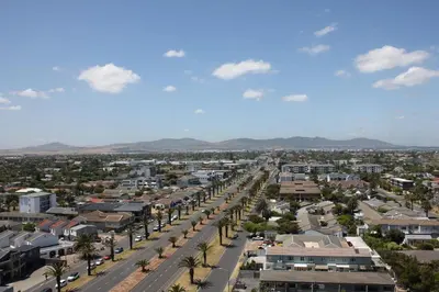 an aerial view of a city with palm trees and buildings at Luxurious 3-bedroom Bloubergstrand Cape Town beachfront apartment with stunning sea and beach view in Cape Town