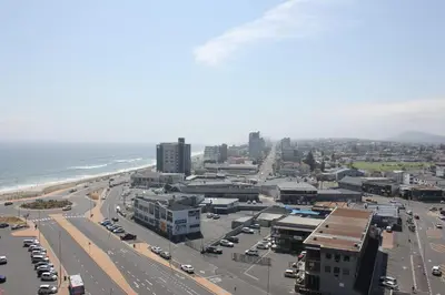 an aerial view of a city with cars parked at Luxurious 3-bedroom Bloubergstrand Cape Town beachfront apartment with stunning sea and beach view in Cape Town