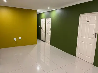 an empty hallway with green and white walls and doors at SNE Travellers in Faure