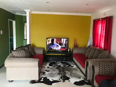a living room with two couches and a tv at SNE Travellers in Faure