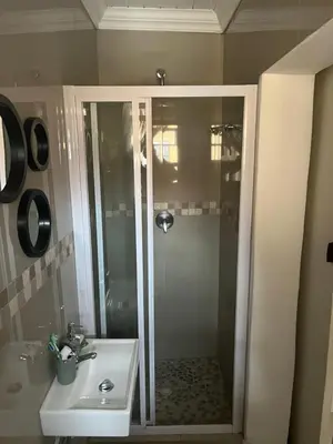 a bathroom with a shower and a sink at SNE Travellers in Faure