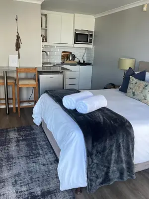 a bedroom with a bed with two towels on it at Apartment Dolphin House in Hermanus