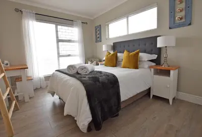a bedroom with a bed with two towels on it at Apartment Dolphin House in Hermanus