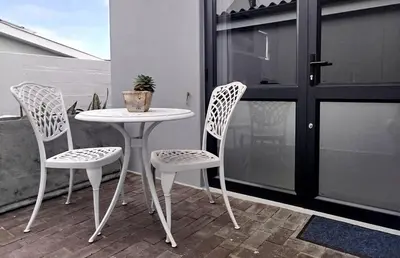 a white table and two chairs on a balcony at Hermanus C-Escape Apartment in Hermanus