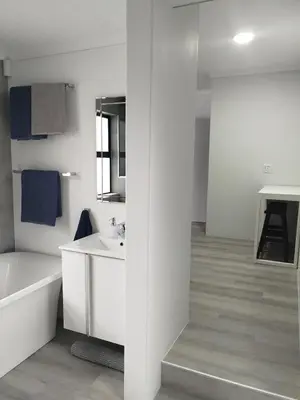 a white bathroom with a tub and a sink at Hermanus C-Escape Apartment in Hermanus