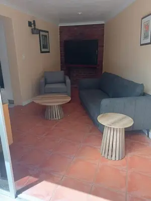 a living room with a couch and a tv at Blouberg Holiday Haven in Cape Town