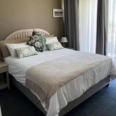 a bedroom with a large bed with pillows on it at Cape Town Beachfront Apartments at Leisure Bay in Cape Town