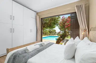 a bedroom with a bed and a large window at 97 Drommedaris by Host Agents in Cape Town