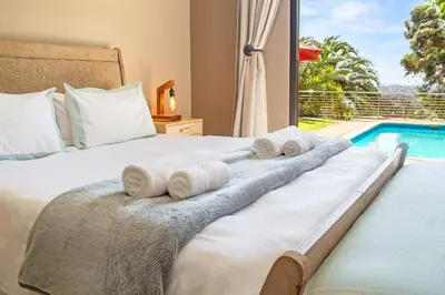 a bedroom with a bed and a swimming pool at 97 Drommedaris by Host Agents in Cape Town
