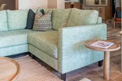 a living room with a green couch and a table at 97 Drommedaris by Host Agents in Cape Town