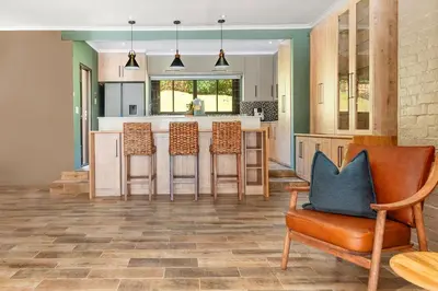 a kitchen with four chairs and a kitchen island at 97 Drommedaris by Host Agents in Cape Town