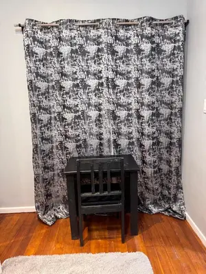 a table in front of a curtain in a room at HavenTrust Guest house in Goodwood