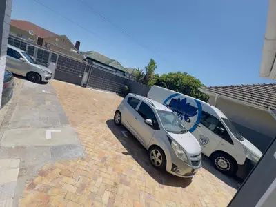 two small cars parked in a parking lot at HavenTrust Guest house in Goodwood