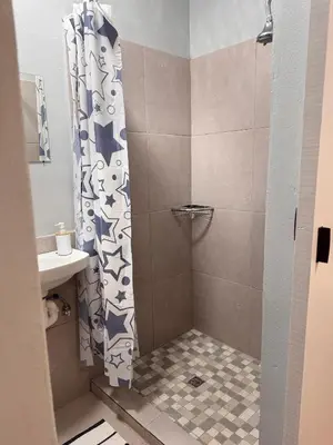 a shower with a shower curtain in a bathroom at HavenTrust Guest house in Goodwood