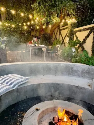 a fire pit in a backyard with a table and chairs at Garden Hideaway in Stellenbosch