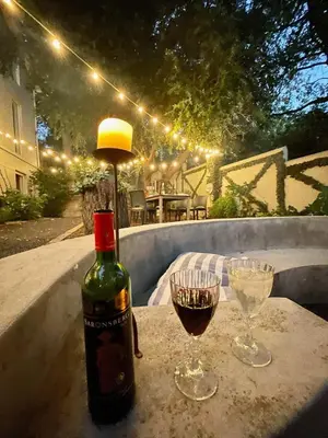 a bottle of wine sitting on a table with two glasses at Garden Hideaway in Stellenbosch
