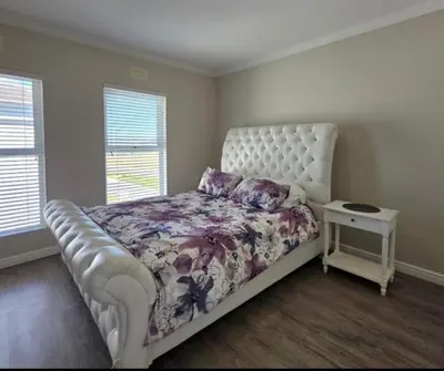 a bedroom with a white bed with a floral bedspread at 53 hillcrest in Oakdale