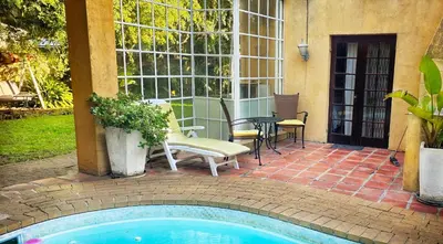 a patio with a pool and a table and chairs at Sunbird room in Cape Town