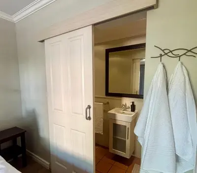 a bathroom with a white door and a sink at 3 Vilaroux in Stellenbosch