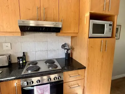 a kitchen with a stove and a microwave at 3 Vilaroux in Stellenbosch