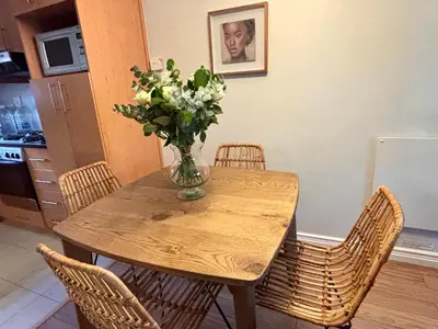 a dining room table with a vase of flowers on it at 3 Vilaroux in Stellenbosch