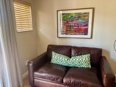 a brown leather couch with two pillows on it at 3 Vilaroux in Stellenbosch