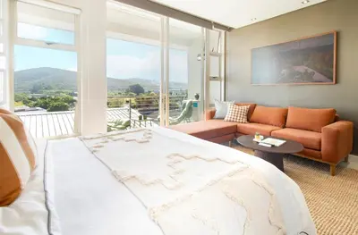 a bedroom with a large bed and a couch at Sonvanger Studio at Andringa Mall Luxury Apartments in Stellenbosch