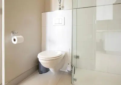 a bathroom with a toilet and a glass shower at Sonvanger Studio at Andringa Mall Luxury Apartments in Stellenbosch