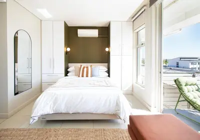 a bedroom with a bed and a large window at Sonvanger Studio at Andringa Mall Luxury Apartments in Stellenbosch