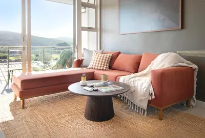 a living room with a couch and a table at Sonvanger Studio at Andringa Mall Luxury Apartments in Stellenbosch