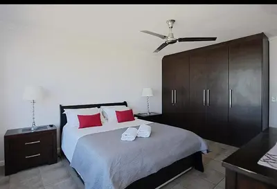 a bedroom with a large bed with red pillows at VIXIRITE APARTMENTS & HOTELs in Cape Town