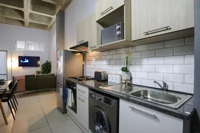 a kitchen with a sink and a washer and dryer at VIXIRITE APARTMENTS & HOTELs in Cape Town