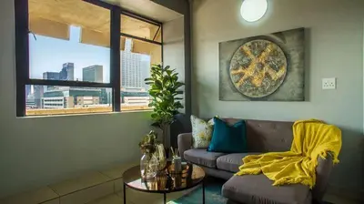 a living room with a couch and a table at VIXIRITE APARTMENTS & HOTELs in Cape Town
