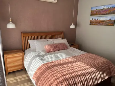 a bed with a pink pillow on top of it at 18 On Louvre Guesthouse in Paarl